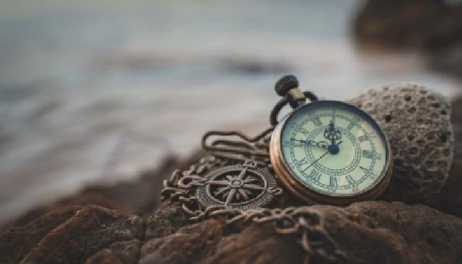 Старий годинник лежить на березі моря на каменях