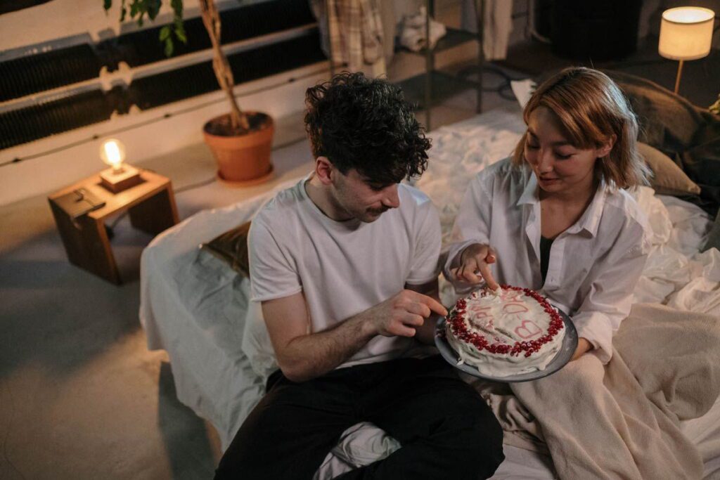 Жінка і чоловік їдять торт на день народження чоловіка