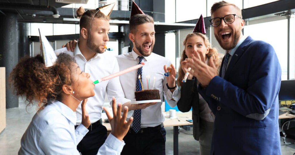 Колеги на роботі в офісі вітають чоловіка з днем народження