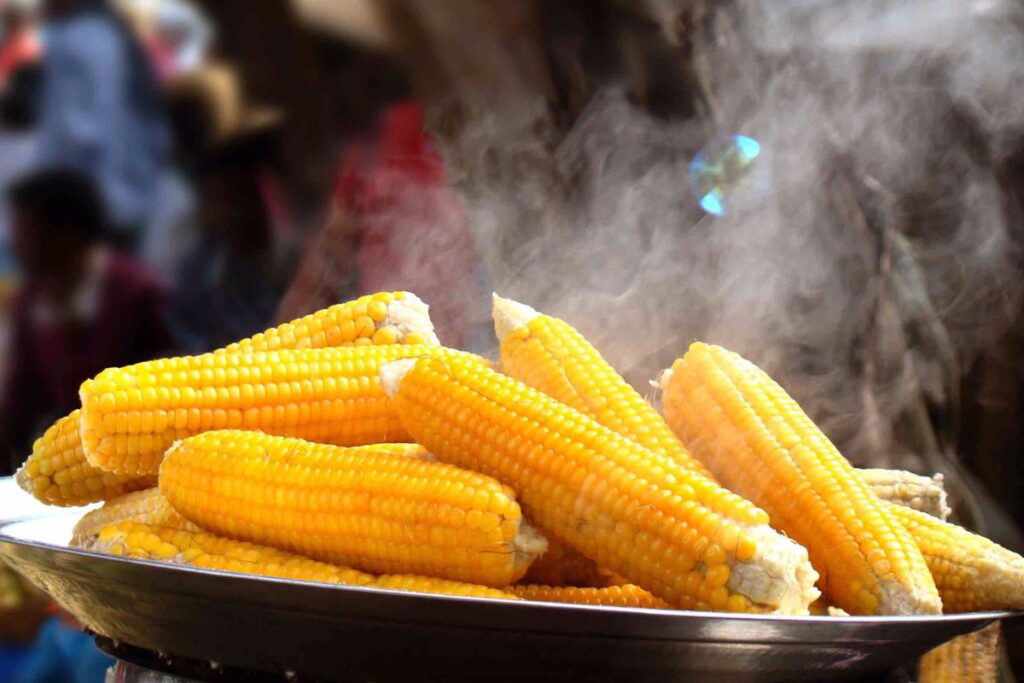 Готова варена кукурудза парує на тарілці