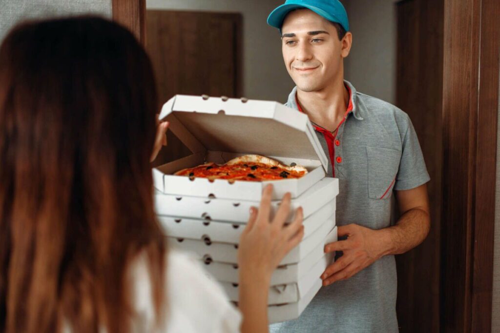 Картинка служби доставки їжі – усміхнений доставщик з коробками піци