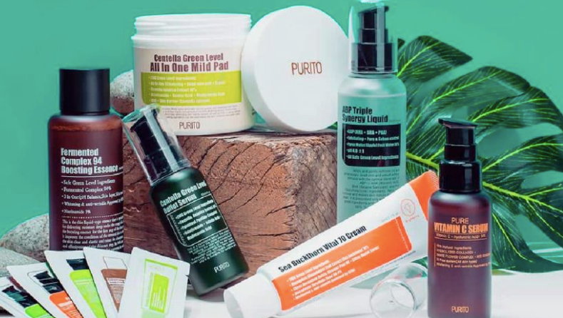 Різні косметичні засоби бренду Purito на зеленому фоні