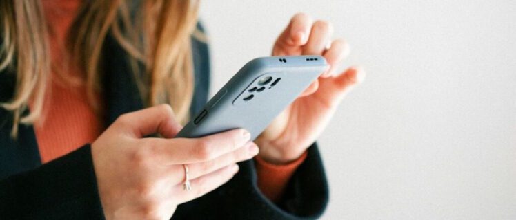 Жінка тримає в руках телефон