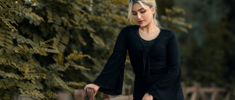 Жінка в чорній сукні в парку