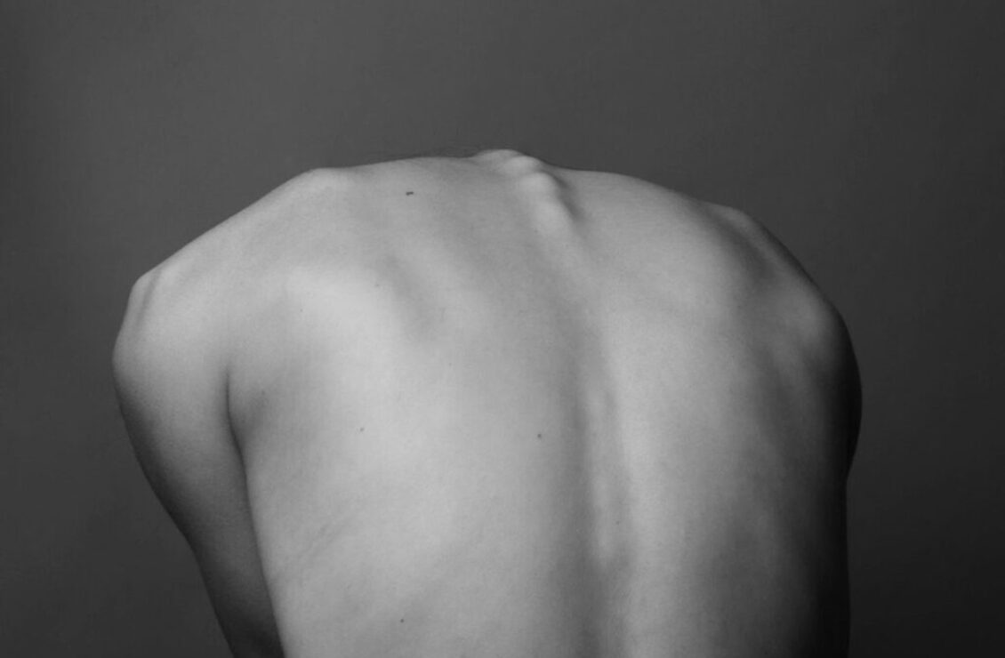 Чорно-білий знімок людини з оголеною спиною