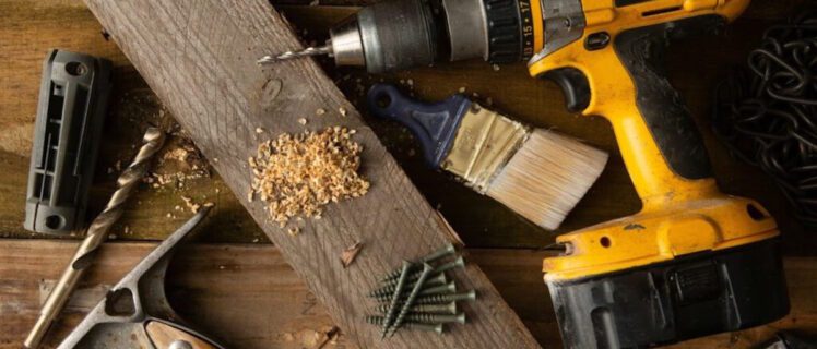 Дриль на робочому місці, поруч із шурупами та свердлами
