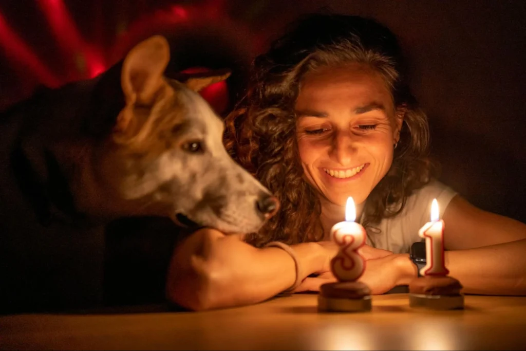 Жінка з собакою дивляться на свічки 31