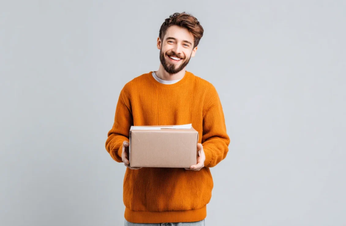 Усміхнений чоловік тримає посилку