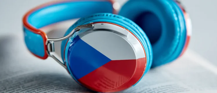 Навушники з прапором Чехії лежать на відкритій книзі