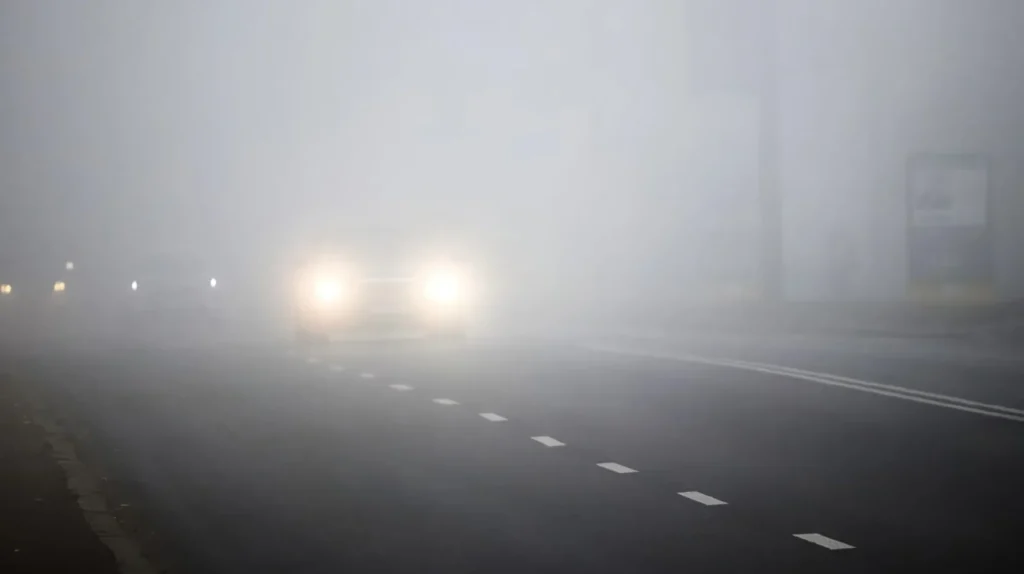 Автомобіль із увімкненим ближнім світлом у тумані