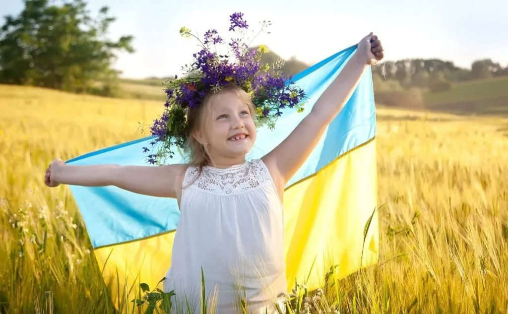 дівчинка у віночку тримає прапор України